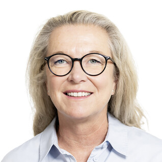 Frau mit runder Brille und hellem Lächeln.